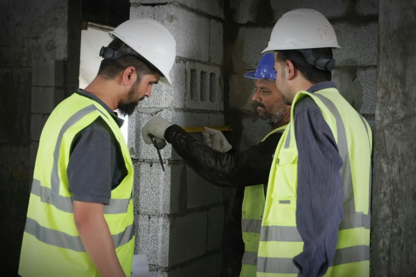 Ingenieros verificando medidas en zona común durante la inspección técnica